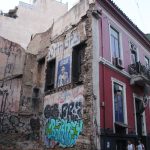 Es wird gezeigt eine Fassade aus einem Haus mit einem Graffiti "Capitalism muss fall"